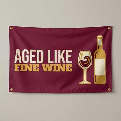 Aged Like Fine Wine flag 3x5 in burgundy with a wine glass and bottle, hung on a wall