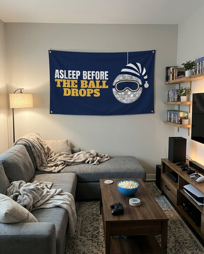 Asleep Before The Ball Drops flag decorating a game room wall