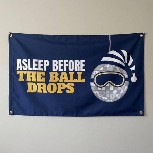 Asleep Before The Ball Drops flag 3x5 in navy with a sleepy disco ball in a nightcap, hung on a wall