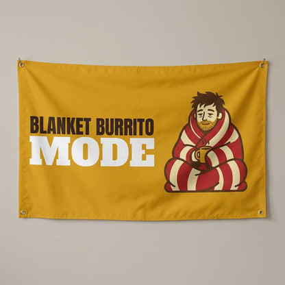 Blanket Burrito Mode flag 3x5 in mustard with a man wrapped in a blanket, hung on a wall