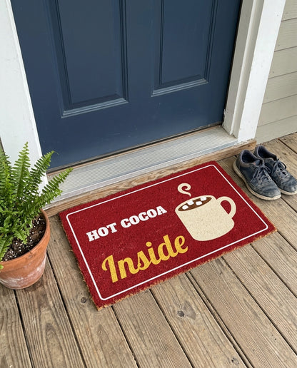 Hot Cocoa Inside winter doormat on a front porch