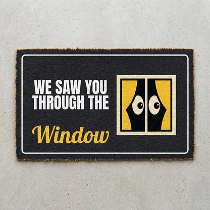 We Saw You Through The Window doormat 30x18 in charcoal with a window and peeking eyes