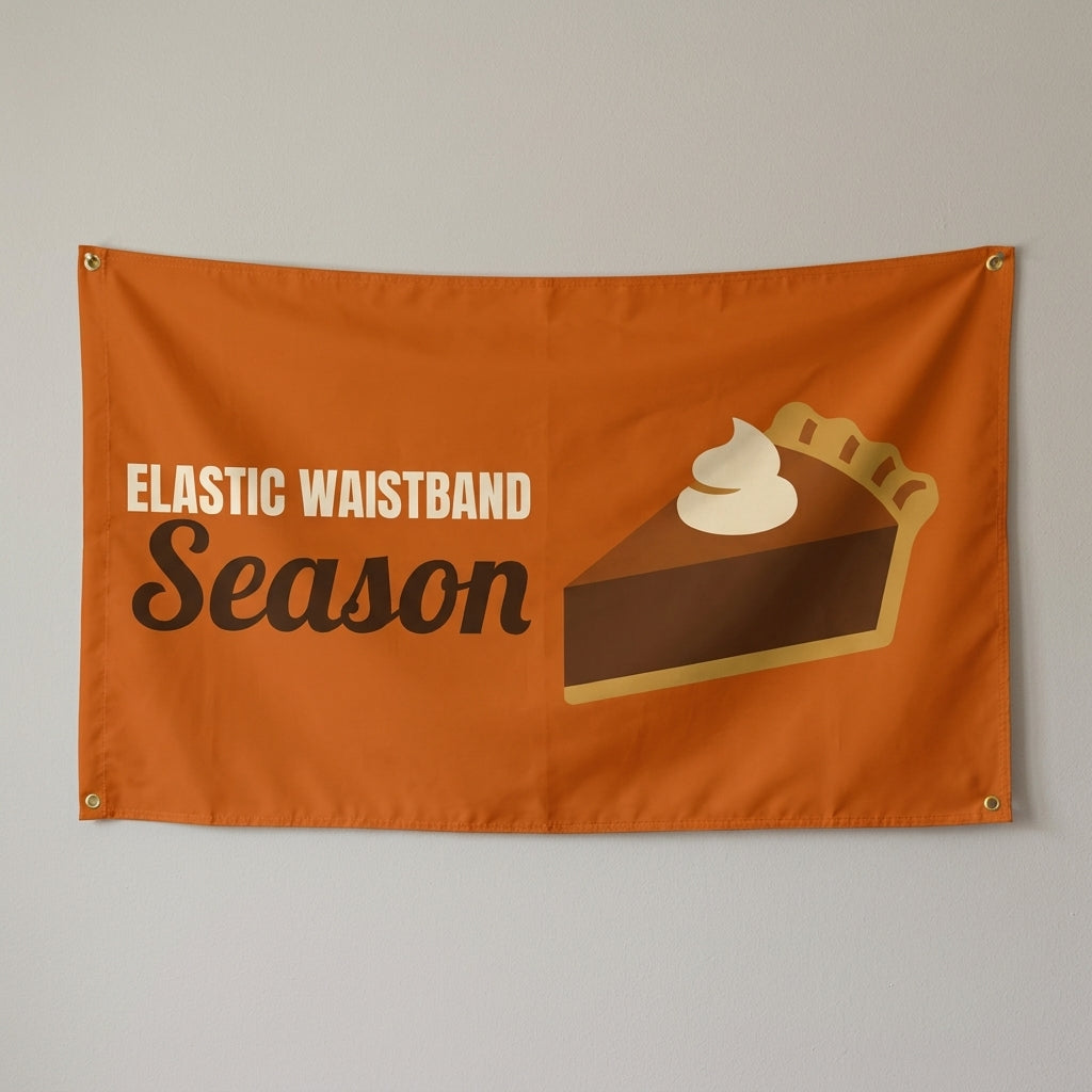 Elastic Waistband Season flag 3x5 in orange with a slice of pie, hung on a wall