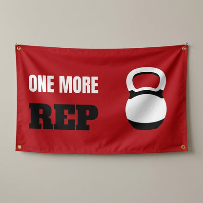 One More Rep flag 3x5 in red with a white kettlebell, hung on a wall
