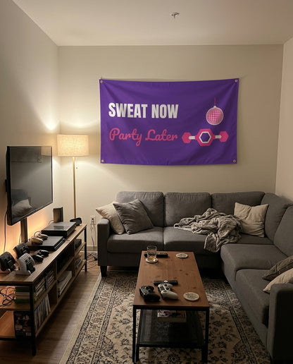 Sweat Now Party Later flag decorating a game room wall