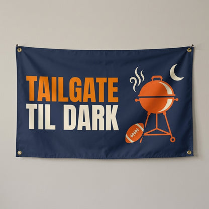 Tailgate Til Dark flag 3x5 in navy with a kettle grill, football and moon, hung on a wall